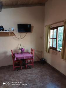 a room with a table and a tv on the wall at Parana Inn in Puerto Iguazú