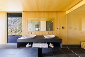 baño con 2 lavabos y espejo grande en Hakuba Jolie Maison by Jade Group, en Hakuba