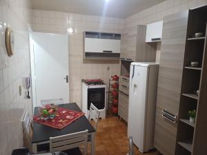a small kitchen with a table and a refrigerator at Apto em Santa Maria in Santa Maria