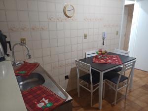 a small kitchen with a table and a sink at Apto em Santa Maria in Santa Maria