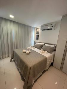 1 dormitorio con 1 cama grande y toallas. en Flat Suites Super Luxo, en Maceió