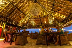 a group of people sitting at tables in a restaurant at Secret Garden Beach Resort in Bangrak Beach
