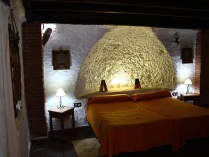 a room with a bed with a large ceiling at Rustic Cave House in Alcudia de Guadix with Pool in Alcudia de Guadix
