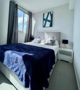 1 dormitorio con 1 cama grande con manta azul en Signature Point Bella Vista, Sea View 2 BR, en Panamá