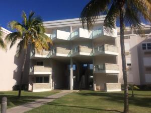 un edificio con palmeras delante en Come, Enjoy & Relax Bosque del Mar 1 Rio Grande, PR en Río Grande