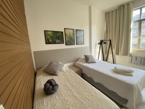 een slaapkamer met 2 bedden en een raam bij Posto 9, Ipanema 2 quartos com suíte in Rio de Janeiro
