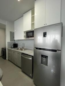 a kitchen with a stainless steel refrigerator and a sink at Signature Point Bella Vista, Sea View 2 BR in Panama City