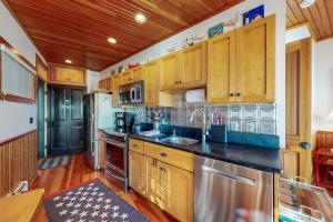 a kitchen with wooden cabinets and stainless steel appliances at Commercial Street Retreat in Provincetown