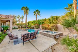 um quintal com uma piscina, uma mesa e cadeiras em Rancho Santana Estate em La Quinta