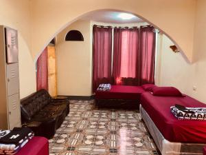 Habitación con 2 camas y sofá. en Mandala’s Hostal, en San Pedro La Laguna