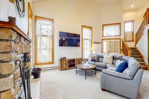 a living room with a couch and a stone fireplace at Casa Lontano in Tannersville