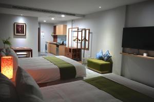 a hotel room with two beds and a kitchen at The MSUG Hotel in Tainan