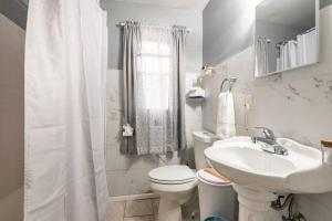 a white bathroom with a toilet and a sink at Mystic Island #1 in Birmingham