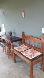 a wooden bench and a table and a table and a table and a bench at Chalé das Alamandas in Socorro