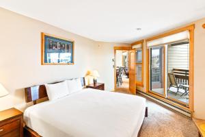 a bedroom with a white bed and a balcony at Lodge at Steamboat A309 in Steamboat Springs