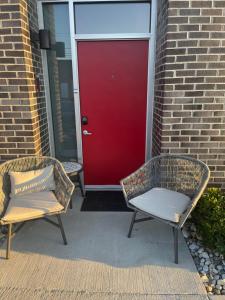 two wicker chairs sitting in front of a red door at Scott’s Addition in Richmond