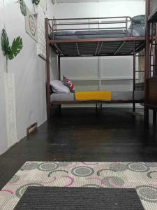 Cette chambre comprend des lits superposés et un tapis. dans l'établissement 大街小巷民宿 Pulau Ketam Street Homestay, à Bagan Teochew
