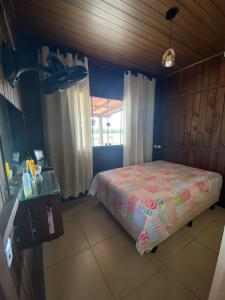 1 dormitorio con 1 cama en una habitación con ventana en Casa Rio da Madre, en Palhoça