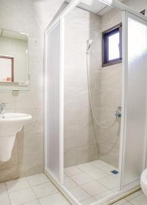 La salle de bains est pourvue d'une douche et d'un lavabo. dans l'établissement Alley-巷弄75包棟民宿, à Yilan