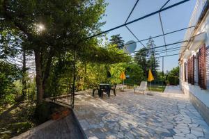 patio z drzewem, stołem i krzesłami w obiekcie Apartment in Malinska - Insel Krk 43310 w mieście Malinska