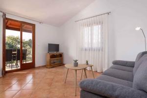 ein Wohnzimmer mit einem Sofa, einem Tisch und einem TV in der Unterkunft Apartments in Porec - Istrien 43248 in Poreč