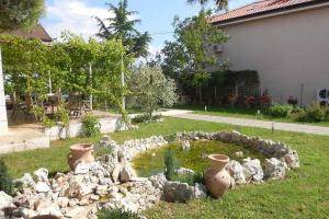 - un jardin avec un étang de rochers dans la cour dans l'établissement Holiday home in Sukosan - Zadar Riviera 43388, à Sukošan