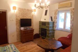 - un salon avec une télévision, un canapé et une table dans l'établissement Holiday home in Sukosan - Zadar Riviera 43388, à Sukošan