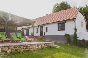 grupa krzeseł siedzących na kamiennej ścianie obok domu w obiekcie Holiday home in Nagyvazsony - Balaton 43410 w mieście Nagyvázsony