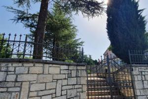 a stone fence with a gate and a tree at Apartment in Novaki Pazinski - Istrien 43267 in Novaki Pazinski