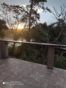 a stone bench on a patio with the sunset in the background at Parana Inn in Puerto Iguazú