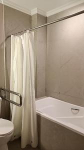 Un baño con una cortina de ducha blanca y un inodoro. en Grand Emilia Hotel, en Cebú