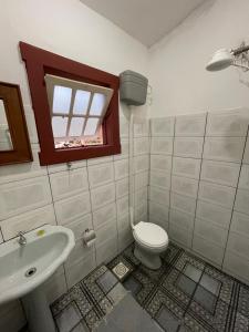 a bathroom with a toilet and a sink and a window at Sobrado da Prainha in Tiradentes