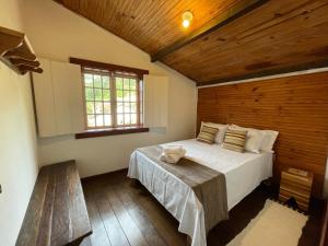 a bedroom with a large bed and a window at Sobrado da Prainha in Tiradentes