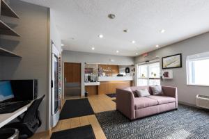 a living room with a couch and a tv at AmericInn by Wyndham Duluth in Duluth