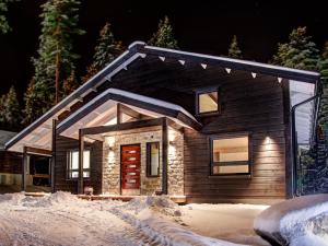 een klein huis met verlichting in de sneeuw bij Villa Borealis in Sappee