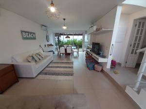 a living room with a couch and a table at Pé na areia em Boiçucanga condominio Aquamarine - perto de Maresias e Camburi in Boicucanga