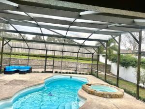 a swimming pool in a greenhouse with a large swimming pool at Dreamy Family Pool House in Clermont