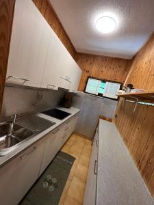 a kitchen with white cabinets and a sink at Apartment in Ledro - Ledrosee 43436 in Ledro