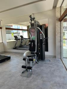 een fitnessruimte met een loopband en een stoel in een kamer bij Mana Beach Sol by Vivere Flats in Porto De Galinhas