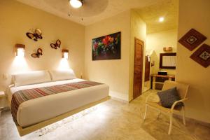 1 dormitorio con 1 cama y 1 silla en una habitación en ALDEA JO-YAH, en Tulum