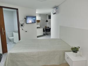 Habitación blanca con cama y baño. en Espetacular Flat Miramar 4, en João Pessoa