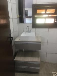 a small bathroom with a sink and a window at Kantinho do Mar in São Francisco do Sul
