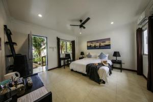 Schlafzimmer mit einem Bett und einem Deckenventilator in der Unterkunft Ocean Vida Beach and Dive Resort in Daanbantayan