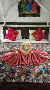 Una cama con un vestido encima. en Putu Guest House Pemuteran en Pemuteran