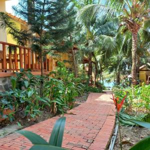 ceglany chodnik przed budynkiem z palmami w obiekcie Viet Thanh Resort w Duong Dong