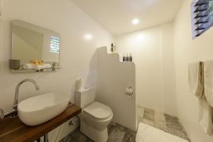 a white bathroom with a toilet and a sink at Ocean Vida Beach and Dive Resort in Daanbantayan