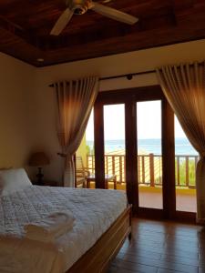 sypialnia z łóżkiem i widokiem na ocean w obiekcie Viet Thanh Resort w Duong Dong