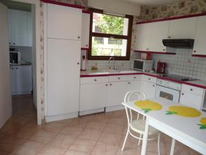 - une cuisine avec des placards blancs, une table et des chaises dans l'établissement Maison Aix-les-Bains, 5 pièces, 6 personnes - FR-1-555-71, à Aix-les-Bains