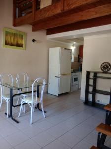 cocina con mesa, sillas y nevera en Apartamento 2 amb, Punta Mogotes en Mar del Plata