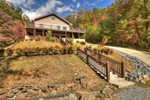 a house on a hill with a wooden fence at The Chariot - Creek Front with HotTub, Fire Pits, Billiards, EV Charger - Sandalwood Stays in Blue Ridge